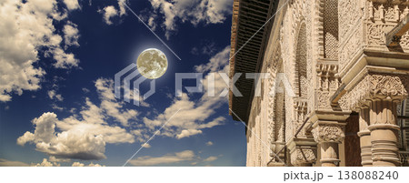 Arches in Islamic (Moorish) style (against the background of a beautiful evening sky with clouds with the super moon) in Alhambra, Granada, Spain Arches in Islamic (Moorish) style (against the background of a beautiful evening sky with clouds with the super moon) in Alhambra, Granada, Spain 138088240
