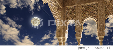 Arches in Islamic (Moorish) style (against the background of a beautiful evening sky with clouds with the super moon) in Alhambra, Granada, Spain Arches in Islamic (Moorish) style (against the background of a beautiful evening sky with clouds with the super moon) in Alhambra, Granada, Spain 138088241