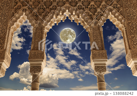 Arches in Islamic (Moorish) style (against the background of a beautiful evening sky with clouds with the super moon) in Alhambra, Granada, Spain Arches in Islamic (Moorish) style (against the background of a beautiful evening sky with clouds with the super moon) in Alhambra, Granada, Spain 138088242