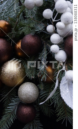 Christmas composition of natural pine branches and gold, bronze, brown and white decorations close-up Christmas composition of natural pine branches and gold, bronze, brown and white decorations close-up 138088311