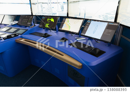 A modern ship bridge featuring a blue navigation console A modern ship bridge featuring a blue navigation console 138088393