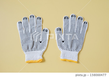 white knitted work gloves on color background. white knitted work gloves on color background. 138088477