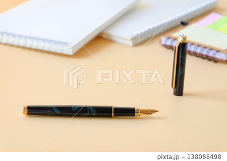 Business fountain pen and book note on color background. 138088498