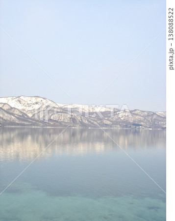 冬の十和田湖、雪山と鏡のような湖面の絶景 138088522