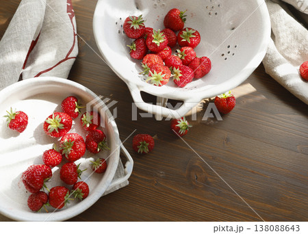 Fresh red strawberries in white ceramic vintage bowl on dark wooden table. Aesthetic food photography showcases organic summer berries for slow living breakfast and cottagecore kitchen vibes. Fresh red strawberries in white ceramic vintage bowl on dark wooden table. Aesthetic food photography showcases organic summer berries for slow living breakfast and cottagecore kitchen vibes. 138088643