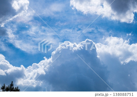 A photograph of a blue summer sky with large, bulky cumulus clouds floating across it, illuminated by sunlight. A template for artwork, screensaver 138088751