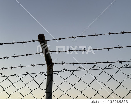 Barbed wire fence under a clear sky with copy space, suitable for background use 138089838