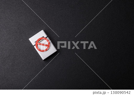 A metal cigarette box with a no smoking sign depicts a harmful habit. A cigarette box A metal cigarette box with a no smoking sign depicts a harmful habit. A cigarette box 138090542