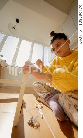 Woman Building Furniture. Woman Engaged In Putting Together Flatpack Furniture In Bright Kitchen Woman Building Furniture. Woman Engaged In Putting Together Flatpack Furniture In Bright Kitchen 138090770
