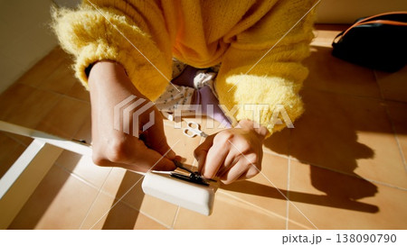 Hands Tighten Hinge. Detailed View Of Hands Adjusting Door Hinge Using Screwdriver Under Warm Light Hands Tighten Hinge. Detailed View Of Hands Adjusting Door Hinge Using Screwdriver Under Warm Light 138090790