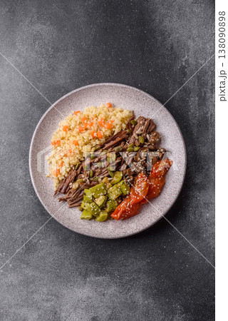 A bowl with beef, porridge, mushrooms, vegetables, sauce, and spices. Beef bowl 138090898