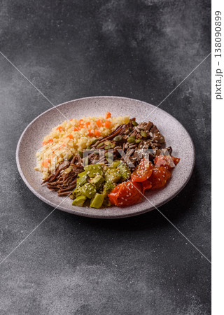 A bowl with beef, porridge, mushrooms, vegetables, sauce, and spices. Beef bowl 138090899