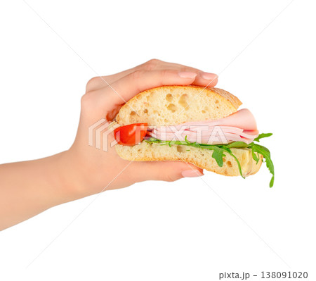 Ham sandwich in hand isolated on white background, deli snack with tomato and arugula Ham sandwich in hand isolated on white background, deli snack with tomato and arugula 138091020