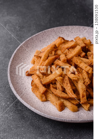Croutons or crackers made from rye bread with garlic, salt, and spices. Croutons with salt Croutons or crackers made from rye bread with garlic, salt, and spices. Croutons with salt 138091530