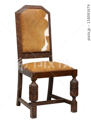 Rustic wooden chair with cowhide seat, showcasing intricate carvings and timeless charm in a cozy rustic setting Rustic wooden chair with cowhide seat, showcasing intricate carvings and timeless charm in a cozy rustic setting 138091674