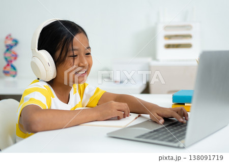 Asian girl with headphones enjoying online class on digital tablet 138091719