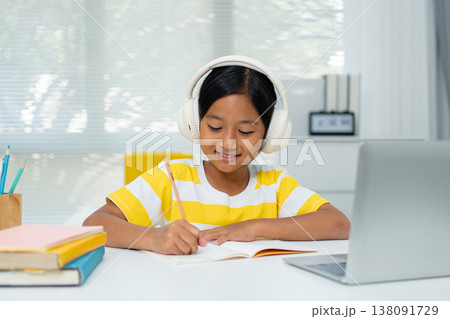 Asian girl with headphones enjoying online class on digital tablet Asian girl with headphones enjoying online class on digital tablet 138091729