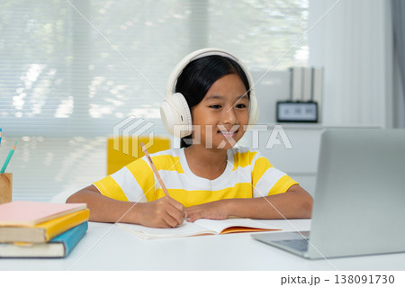 Asian girl with headphones enjoying online class on digital tablet Asian girl with headphones enjoying online class on digital tablet 138091730