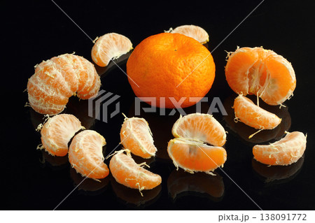 Peeled fresh tangerines with leaves on a black stone surface. Near mandarin slices. Seasonal citrus fruits, natural healthy foods. Close-up. Black stone background. Copyspace for text. Peeled fresh tangerines with leaves on a black stone surface. Near mandarin slices. Seasonal citrus fruits, natural healthy foods. Close-up. Black stone background. Copyspace for text. 138091772