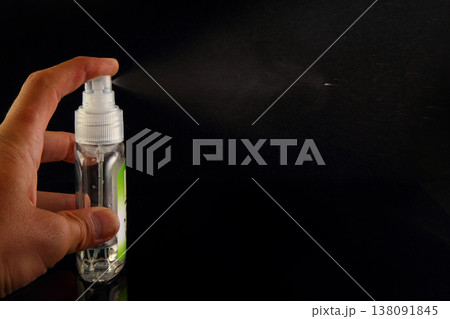A Person's Hand Spraying Breath Freshener On Black Background A Person's Hand Spraying Breath Freshener On Black Background 138091845