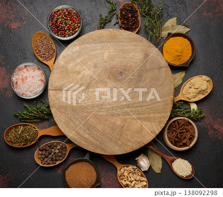 Spices around a round wooden board. Copy space 138092298