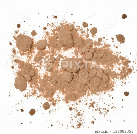 Spilled cocoa powder with small lumps, forming an uneven textured spot on a white background. Spilled cocoa powder with small lumps, forming an uneven textured spot on a white background. 138092355