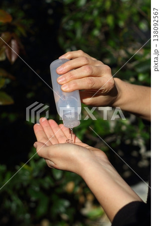 COVID-19 Pandemic Coronavirus woman hands using wash hand sanitizer gel dispenser, against Novel coronavirus (2019-nCoV) or Wuhan coronavirus in city street. Antiseptic, Hygiene and Healthcare concept 138092567