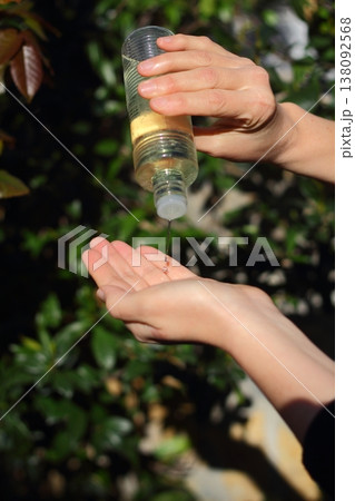 COVID-19 Pandemic Coronavirus woman hands using wash hand sanitizer gel dispenser, against Novel coronavirus (2019-nCoV) or Wuhan coronavirus in city street. Antiseptic, Hygiene and Healthcare concept 138092568