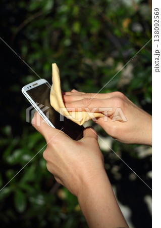 Close Up Of Hands Cleaning And Disinfecting The Phone 138092569
