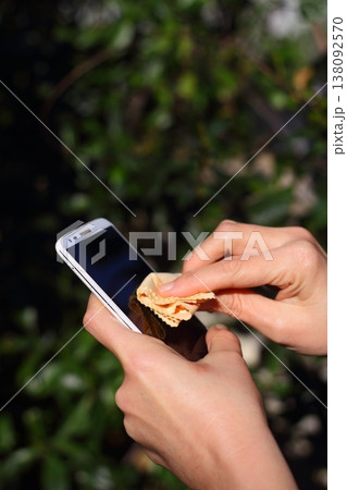 Close Up Of Hands Cleaning And Disinfecting The Phone Close Up Of Hands Cleaning And Disinfecting The Phone 138092570