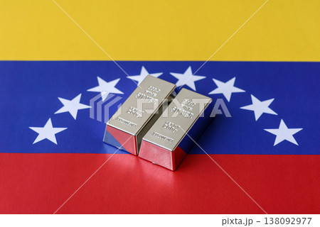 A silver bar, white metal against a flag of venezuela, as a concept for the sales. A silver bar A silver bar, white metal against a flag of venezuela, as a concept for the sales. A silver bar 138092977