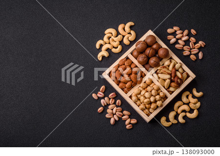 Wooden box with macadamia nuts, almonds, pistachios, and hazelnuts. Nuts as a food background Wooden box with macadamia nuts, almonds, pistachios, and hazelnuts. Nuts as a food background 138093000