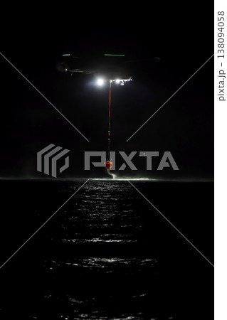 night vision firefighting helicopter takes water from the sea. 138094058