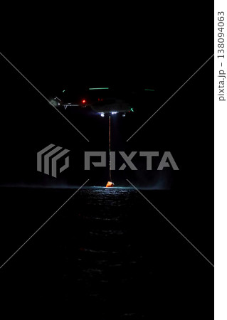 night vision firefighting helicopter takes water from the sea. 138094063