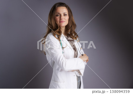 Serious Female Practitioner with Crossed Arms in Lab Coat 138094359