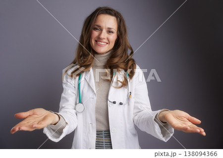 Friendly Female Doctor with Welcoming Hand Gesture 138094366