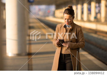Woman with Crutch Using Tablet on Train Platform Woman with Crutch Using Tablet on Train Platform 138094412
