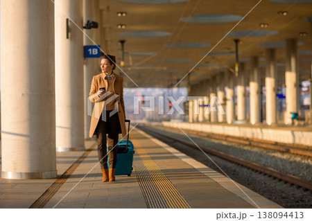 Woman Using Smartphone While Walking at Train Station 138094413
