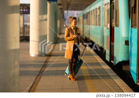 Solo Female Traveler Navigating Train Station with Smartphone 138094417