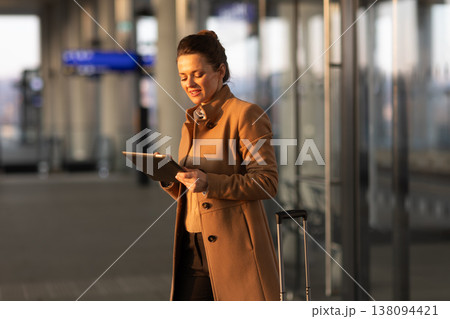 Woman Reviewing Digital Travel Ticket at Station Woman Reviewing Digital Travel Ticket at Station 138094421