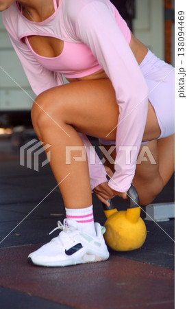 Strength training with kettlebell and engaged core muscles emphasized 138094469