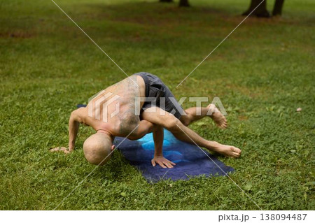 Bald individual performs impressive onearm planche outdoors 138094487