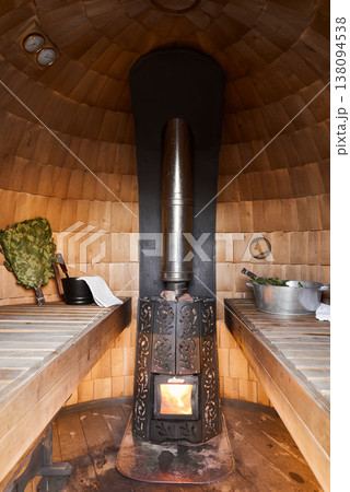 Cozy Wooden Benches And Burning Firelight Create Immersive Traditional Bathhouse Atmosphere 138094538