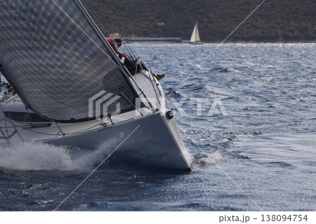 Close up on the bow of a sailboat breaking through a wave Close up on the bow of a sailboat breaking through a wave 138094754