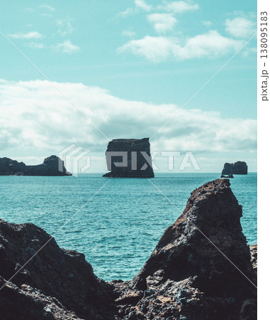 Dramatic seascape with rock formations at Dyrholaey, South Iceland, under a bright sky 138095183