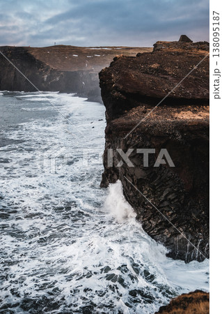 Dramatic ocean waves crash against the basalt cliffs of Dyrholaey, South Iceland. 138095187
