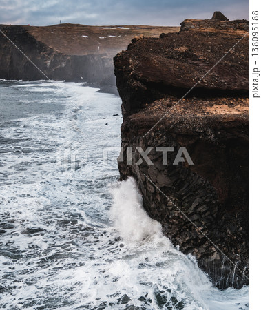 Dramatic ocean waves crash against the basalt cliffs of Dyrholaey, South Iceland. 138095188