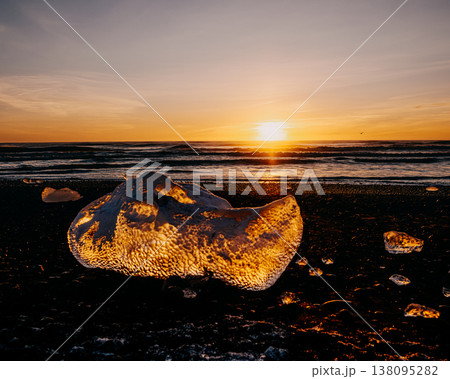 Golden sunset illuminating glacial ice on Diamond Beach (Breidamerursandur), South Iceland. 138095282