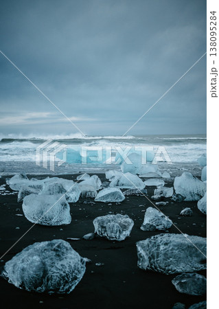 Scattered glacial ice on Diamond Beach under a moody sky, South Iceland. Scattered glacial ice on Diamond Beach under a moody sky, South Iceland. 138095284