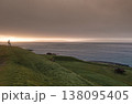 Solitary figure contemplates sunset over historical Torshavn coastline 138095405